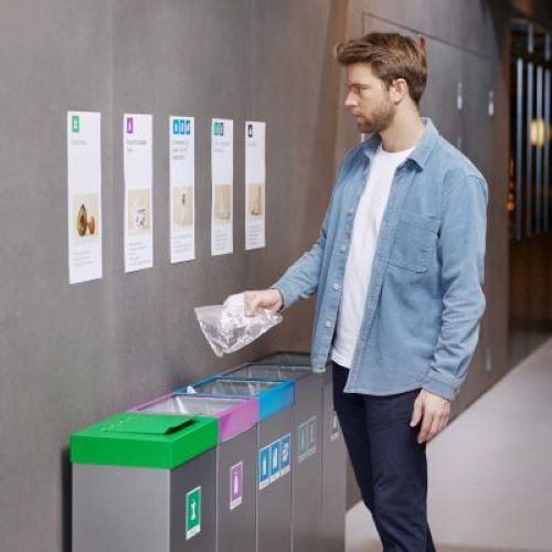 En person som kildesorterer en flaske