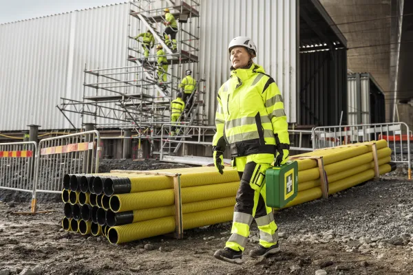 En person med mobilt førstehjelpssett på ett byggeområde