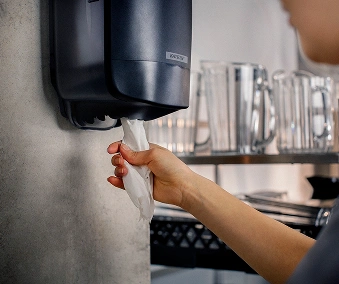 En person som bruker en håndtørkdispenser